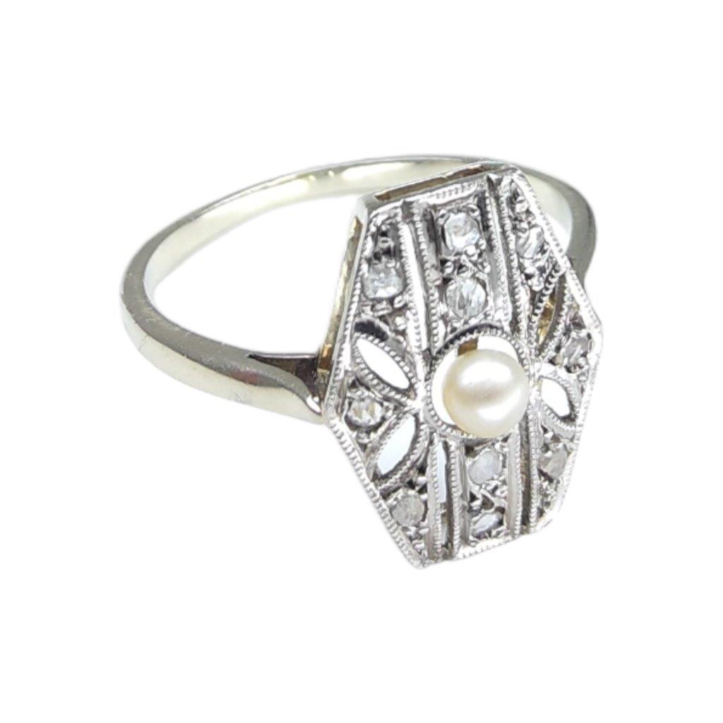 Zlatý prsten o ryzosti Au 750/1000 se zasazenou říční perličkou diamanty, vrchní část hlavy je z platiny . Celková hmotnost 2,25 g